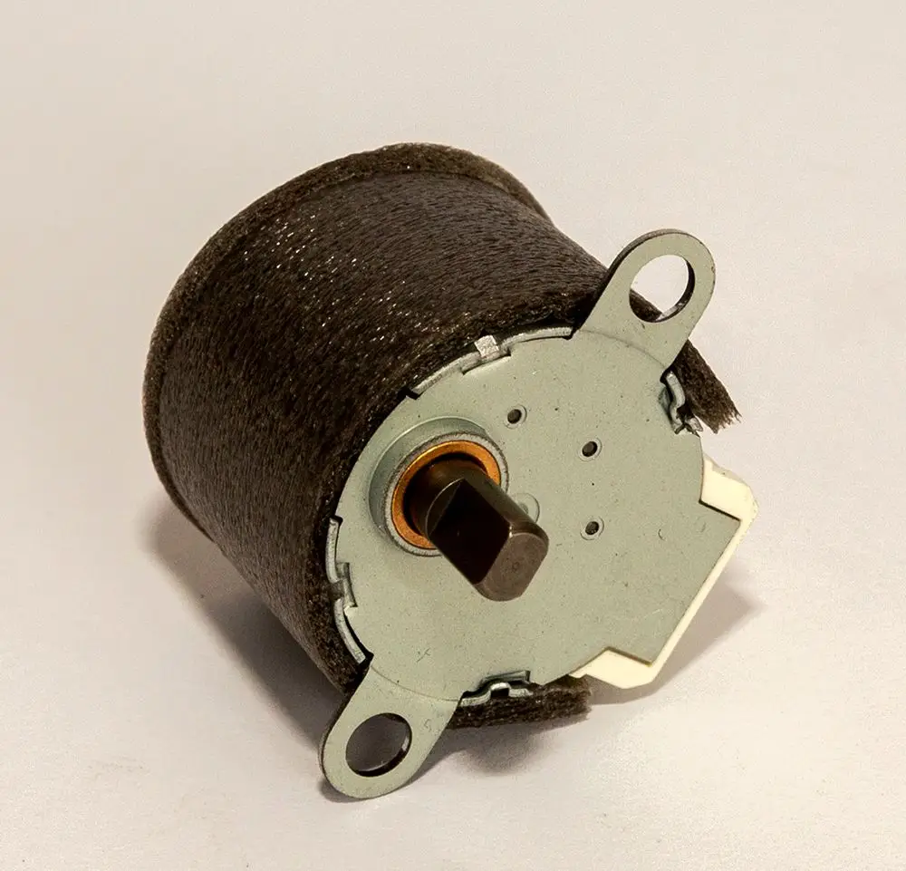Daikin Pendelmotor, runder Motor mit metallischer Unterseite und einem Anschluss, der für die Verwendung in Heizlösungen konzipiert ist.